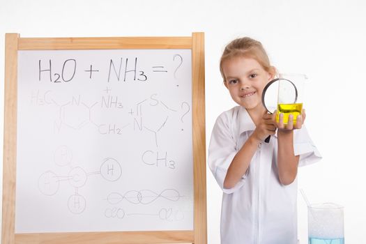 Five-year girl chemist standing at an easel in a bathrobe