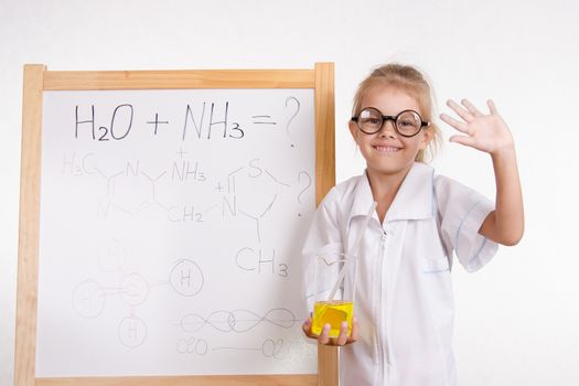 Five-year girl chemist standing at an easel in a bathrobe