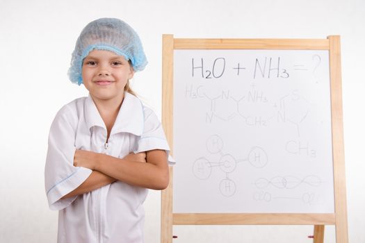 Five-year girl chemist standing at an easel in a bathrobe