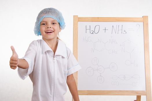 Five-year girl chemist standing at an easel in a bathrobe