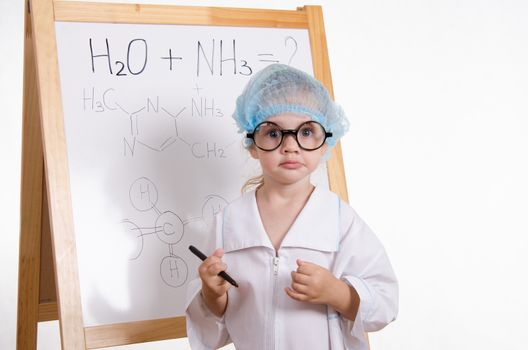 Three year old girl chemist standing at blackboard robe