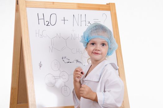 Three year old girl chemist standing at blackboard robe