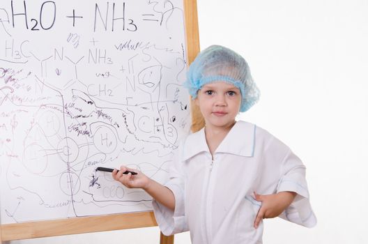 Three year old girl chemist standing at blackboard robe