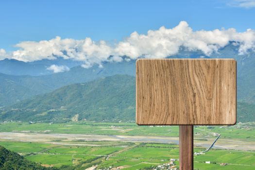 Blank wooden sign on field of farm. Concept of rural, idyllic, tranquility etc.