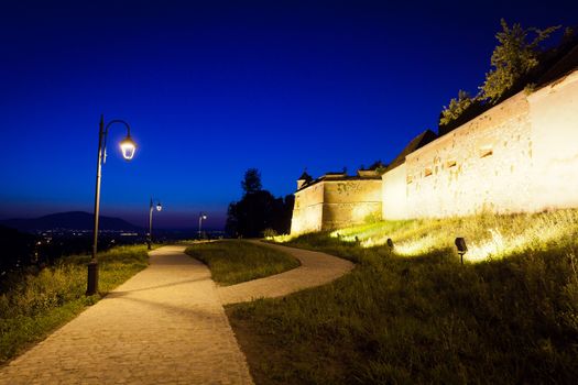 Alley arround old  fortress "Cetatuia" illuminated at night, Brasov, Romania