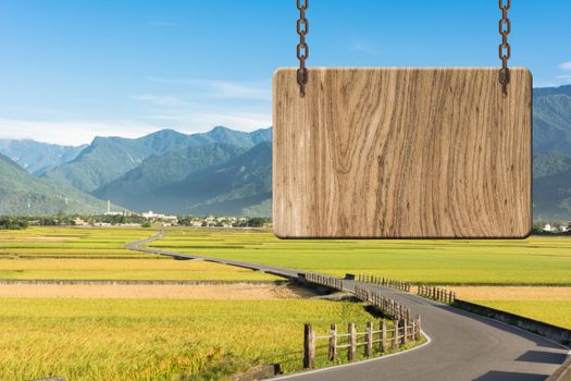 Blank wooden sign on field of farm. Concept of rural, idyllic, tranquility etc.