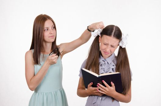Teacher bangs his hand on the head and scolds student