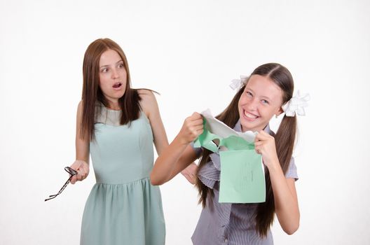Schoolgirl having fun tearing the notebook in front of an angry teacher