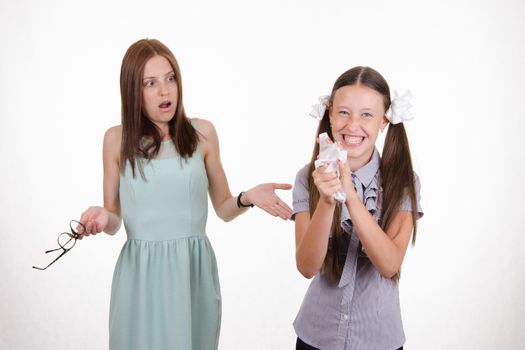 Schoolgirl having fun tearing the notebook in front of an angry teacher