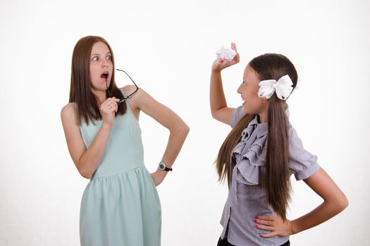 Schoolgirl having fun tearing the notebook in front of an angry teacher
