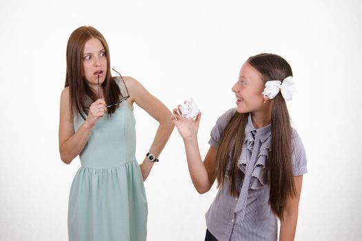 Schoolgirl having fun tearing the notebook in front of an angry teacher