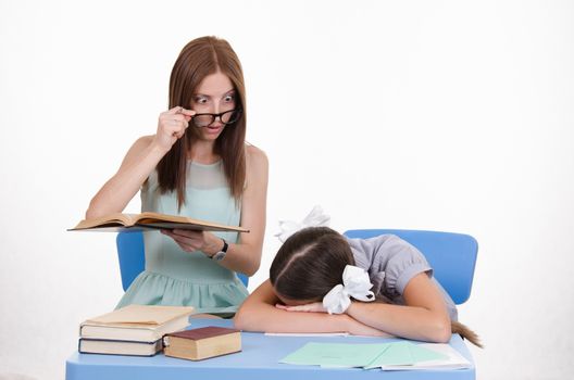 The teacher teaches student who fell asleep from boredom