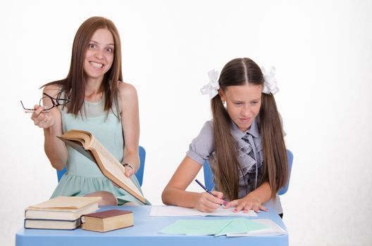 The teacher is angry with the student sitting with him at the table