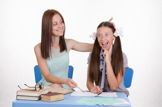 The teacher teaches the student sitting with him at the table