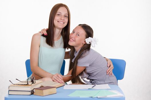 The teacher teaches the student sitting with him at the table