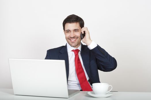 young business executive in suit behind desk with laptop