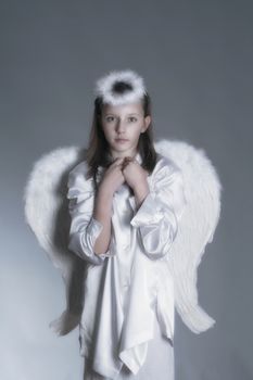 studio portrait of an eleven years old girl dressed as angel