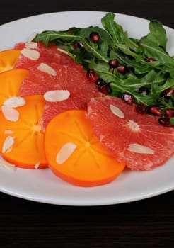 Salad of grapefruit, persimmon, arugula, almonds and pomegranate