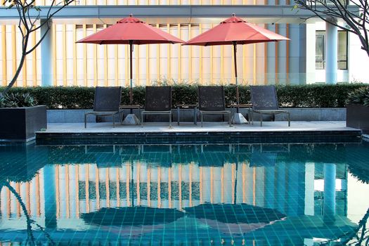 beautiful swimming pool with sunbeds and beach umbrella 