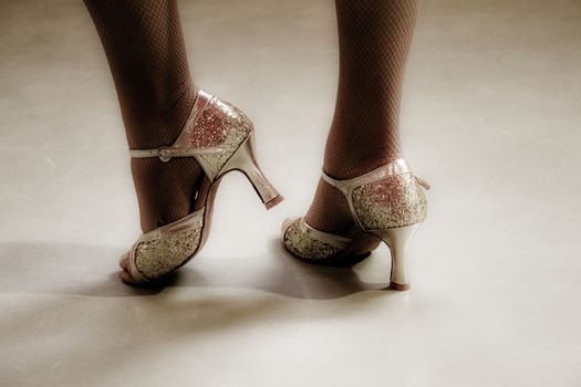 Woman with golden latin shoes dancing on the floor.