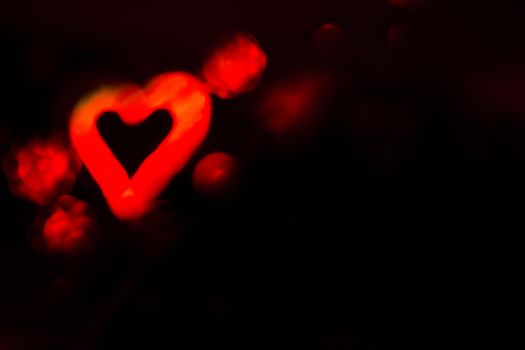 Red heart with black background simulating cupid arrow.