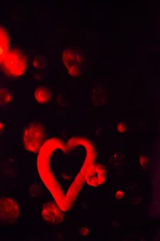 Red Heart with cotton clouds on black background. Vertical rectangular artistic color digital photo.