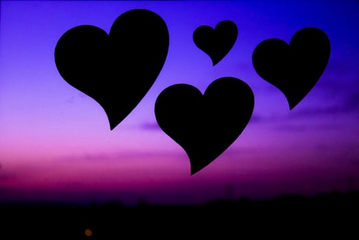 Three hearts floating in the blue sky and purple.