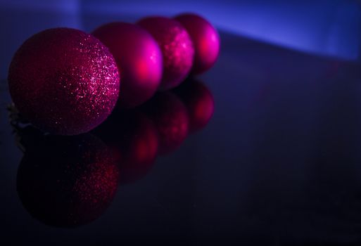 Christmas Ornament. Red christmas tree balls over black and blue background. Horizontal. Space.