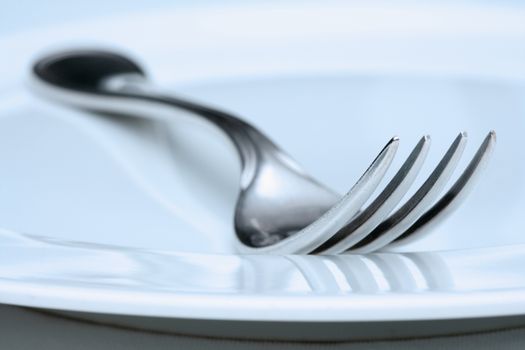 silverware and plate-extreme closeup of a fork - blue tint