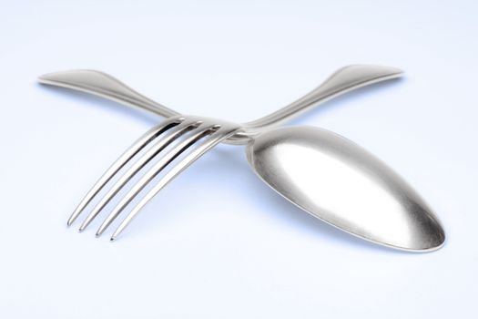elegant silverware- closeup of a fork and spoon on blue background