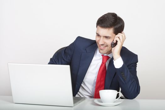 young business executive in suit behind desk with laptop