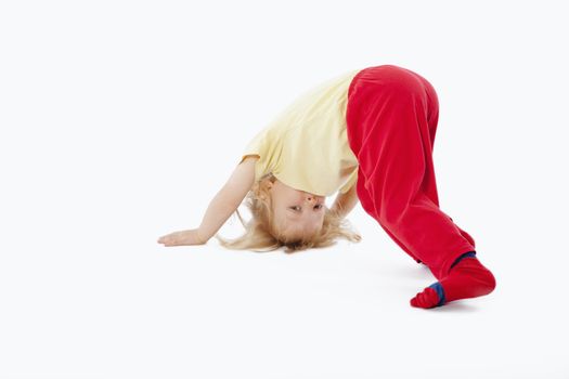 boy with long blond hair trying to stand on his head