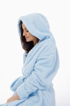 attractive brunette in blue bathrobe with hood isolated on white