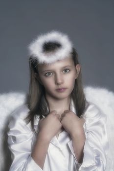 studio portrait of an eleven years old girl dressed as angel