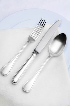 elegant silverware setting on plate with white cloth