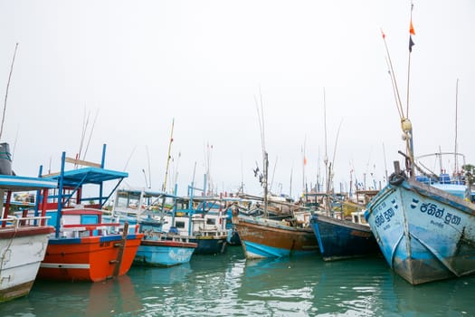 TANGALLE, SOUTHERN PROVINCE, SRI LANKA, ASIA - DECEMBER 20, 2014: Colorful wood fishing boats moored on December 20, 2014 in Tangalle port, Southern Province, Sri Lanka.