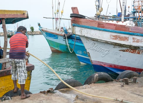 TANGALLE, SOUTHERN PROVINCE, SRI LANKA, ASIA - DECEMBER 20, 2014: Colorful wood fishing boats moored on December 20, 2014 in Tangalle port, Southern Province, Sri Lanka.