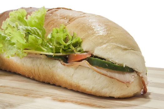 Sandwich in deep depth of field on wooden board.