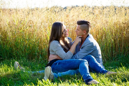 portrait of happy smiling young couple in love embracing outdoor at sunny day