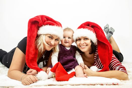 smiling infant baby with mother and her aunt with santa hats