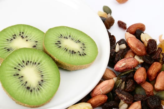 Bowl of mixed nuts and kiwi fruit on a white background