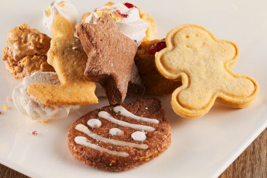 Christmas biscuits over white plate, horizontal image