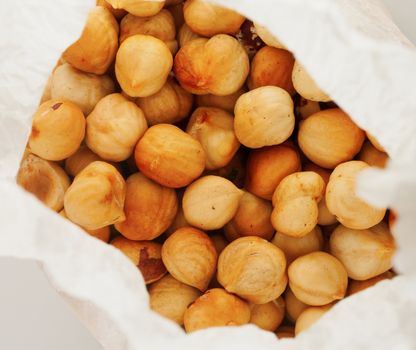 Peeled hazelnuts in a paper bag, seen from above