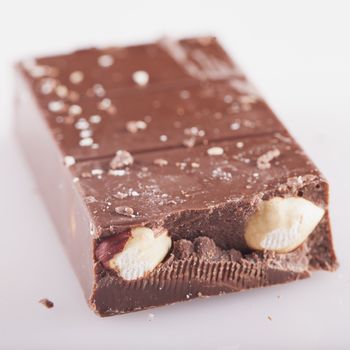 Chocolate piece with nuts, white background, square image