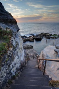 Steep stairs lead down the cliff face to Giles Baths rockpool on the northern end of Coogee, Sydney Australia. 