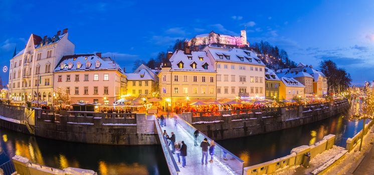 Ljubljana in Christmas time. Lively nightlife in old medieval city center decorated with Christmas lights. Slovenia, Europe. Shot at dusk with fish eye lens.