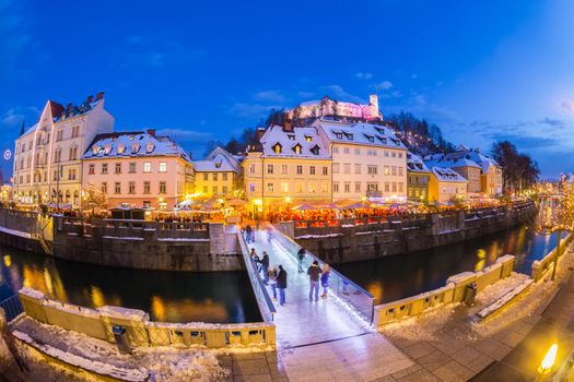 Ljubljana in Christmas time. Lively nightlife in old medieval city center decorated with Christmas lights. Slovenia, Europe. Shot at dusk with fish eye lens.