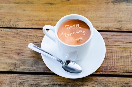 Cup of coffee with milk. Milk foam font Good Morning