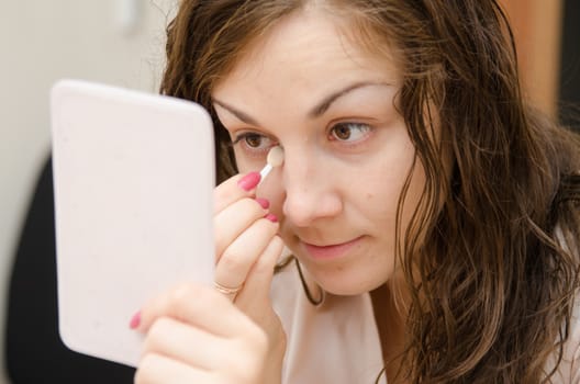 Young girl puts makeup in the office workplace