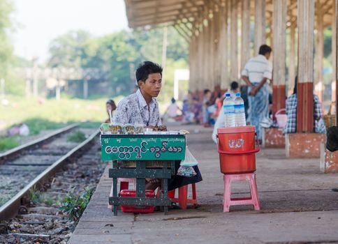 Yangon, Myanmar - November 13, 2014: Vendor selling refreshments and cigarettes to passengers at the platform of Pan Hlaing Railway Station in Yangon, Myanmar.